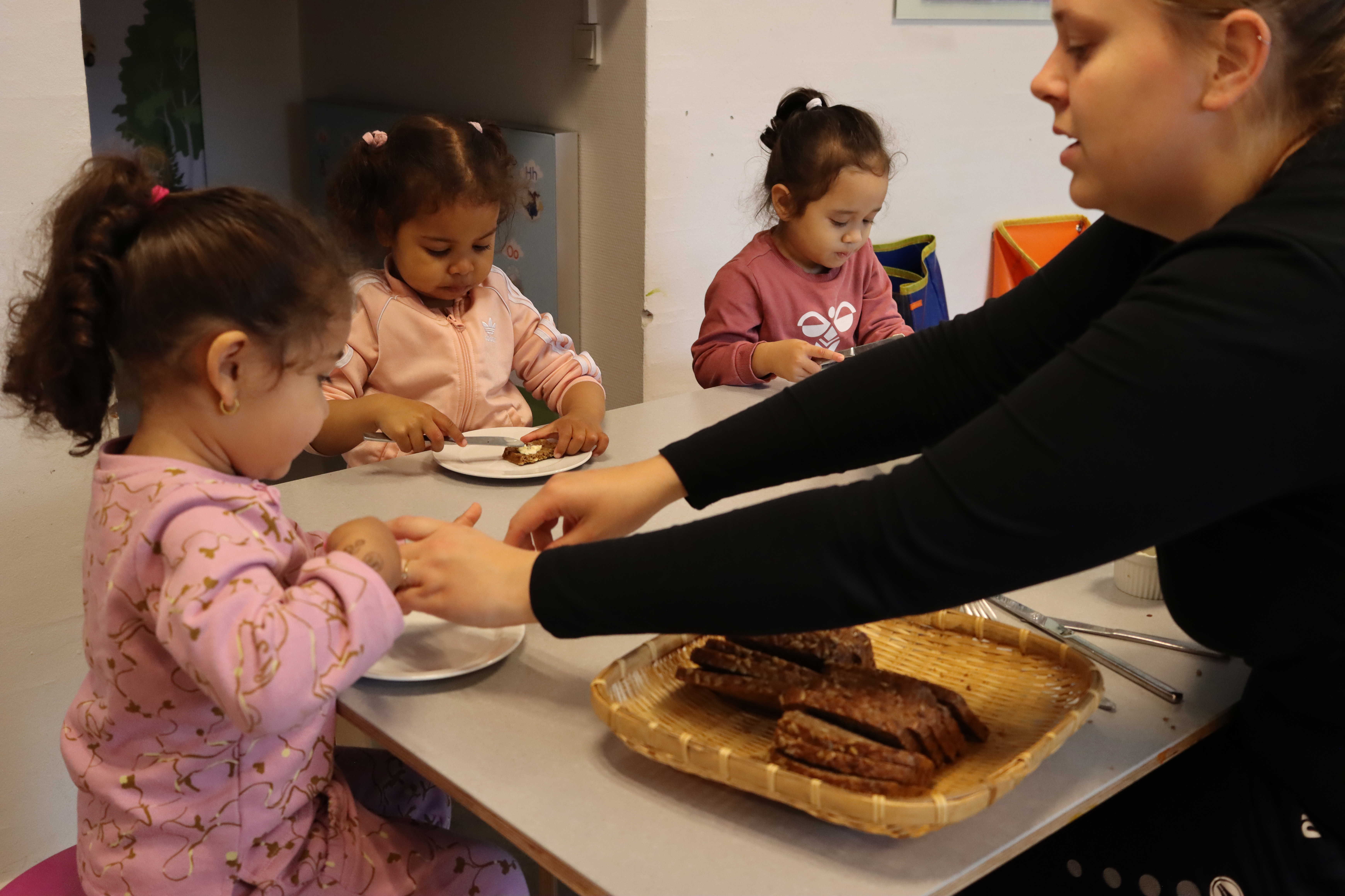 Børnene lærer selv at hælde vand op og smøre brødet - vi giver en hjælpende hånd, når der er brug for det