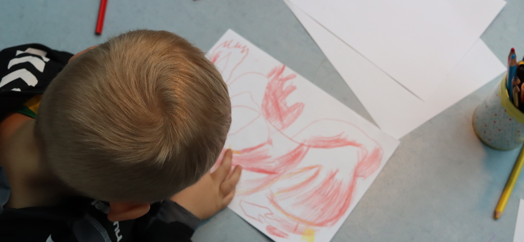 Dreng sidder og tegner - vi giver børnene mulighed for at fordybe sig